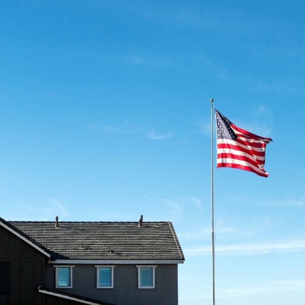 House with American flag against blue sky.