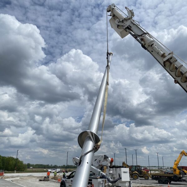 Construction site with crane and metal pole.